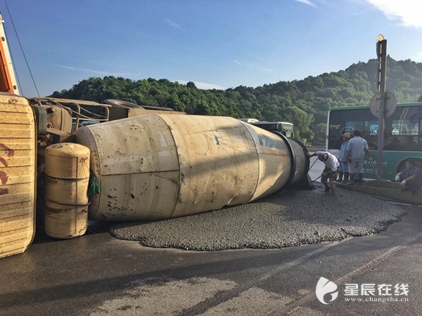 发生侧翻,混凝土洒一地,交警已赶到现场处理,事故原因正在进一步调查